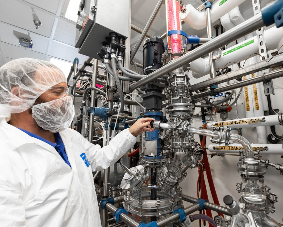 A manufacturing worker standing near equipment in our CDMO facility